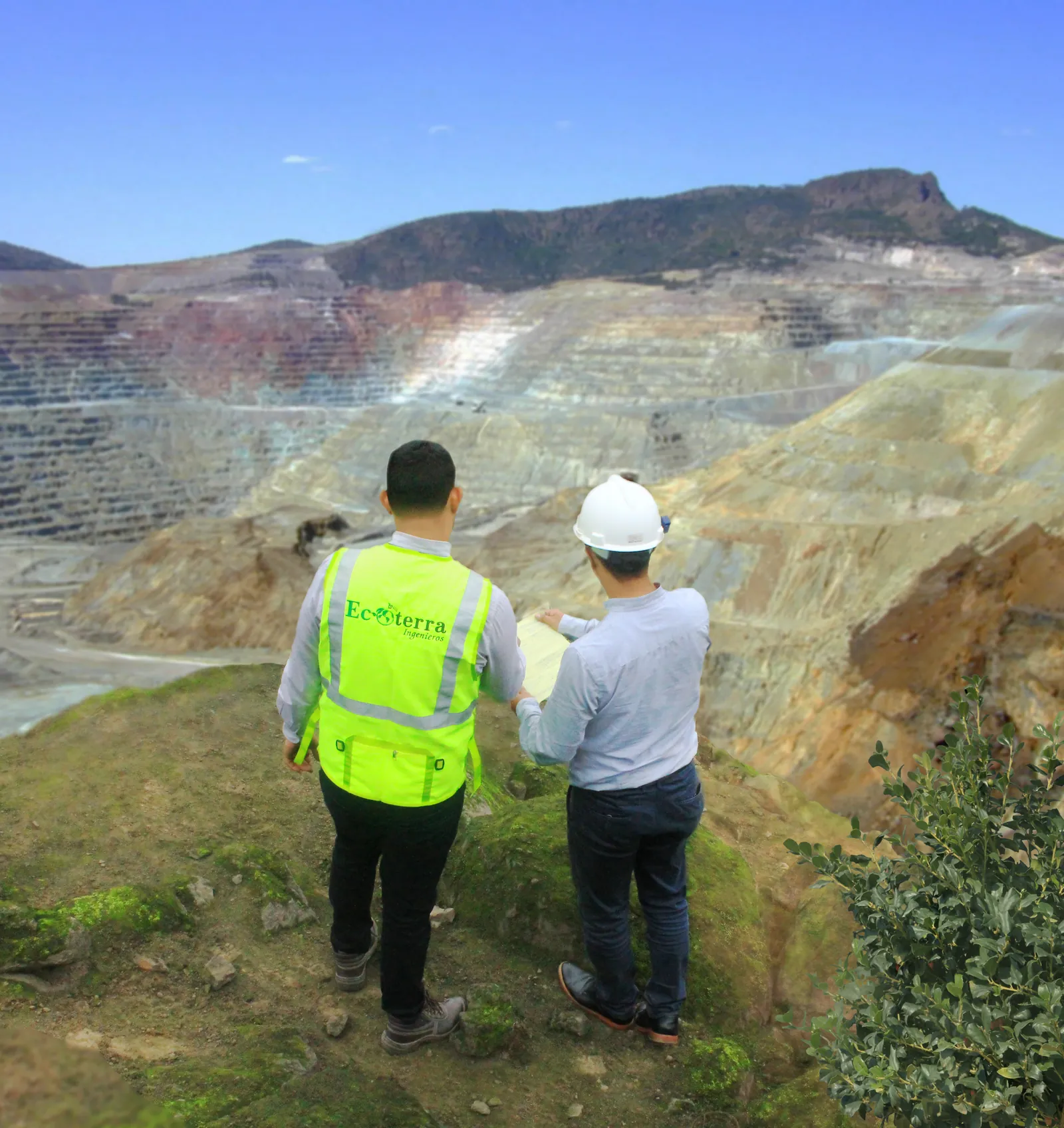 Equipo de Ecoterra revisando planos frente a una mina a tajo abierto