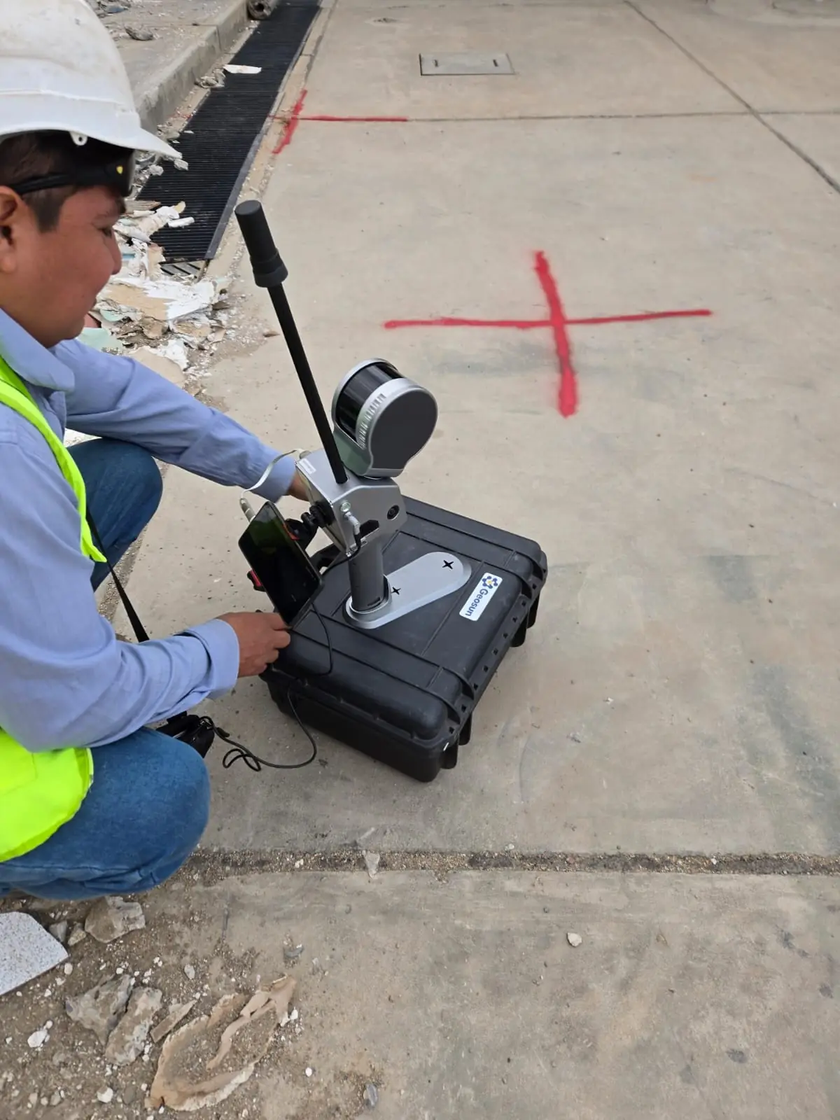 Técnico inicializando el escáner SLAM sobre su estuche antes del recorrido